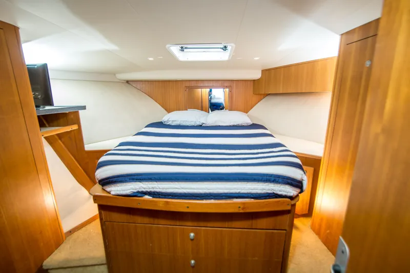 Slide: The Image of Luxurious cabin interior of 2002 Luhrs 36 Convertible yacht with cozy bed and wooden finish. - 21