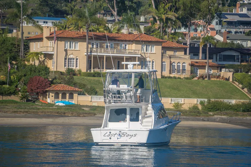 Slide: The Image of 2002 Luhrs 36 Convertible yacht on water near luxurious waterfront mansion. - 5