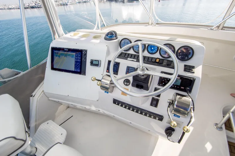Slide: The Image of 2002 Luhrs 36 Convertible helm with navigation equipment and steering wheel, overlooking marina. - 6