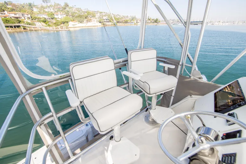 Slide: The Image of 2002 Luhrs 36 Convertible boat helm with two white captain chairs overlooking serene water. - 7