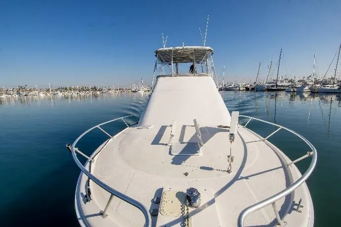 Slide: The Image of 2002 Luhrs 36 Convertible yacht on calm water, marina in background. - 9