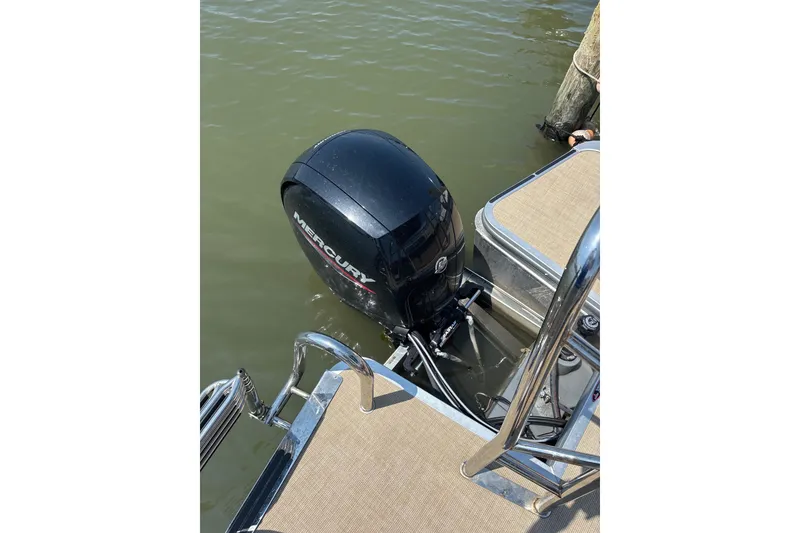 Slide: The Image of 2024 Harris HCX23 boat with Mercury outboard motor on calm water. - 10