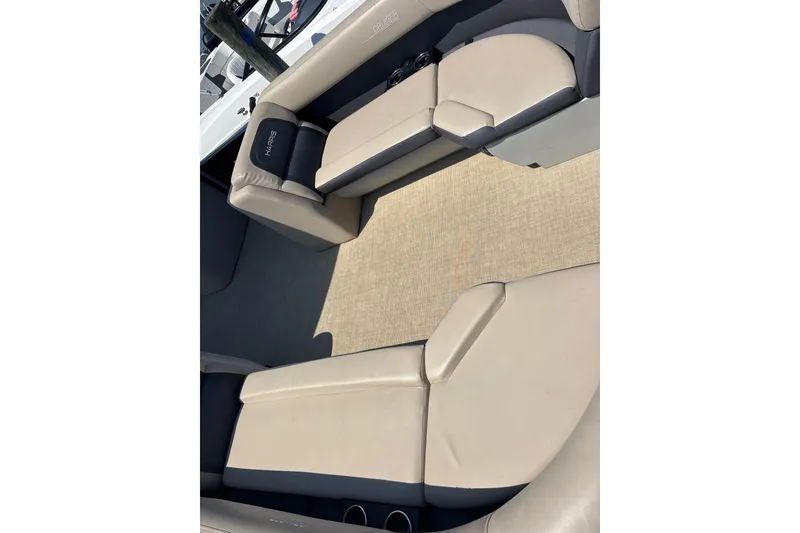 Slide: The Image of 2024 Harris HCX23 boat interior with beige seating and carpet flooring. - 7