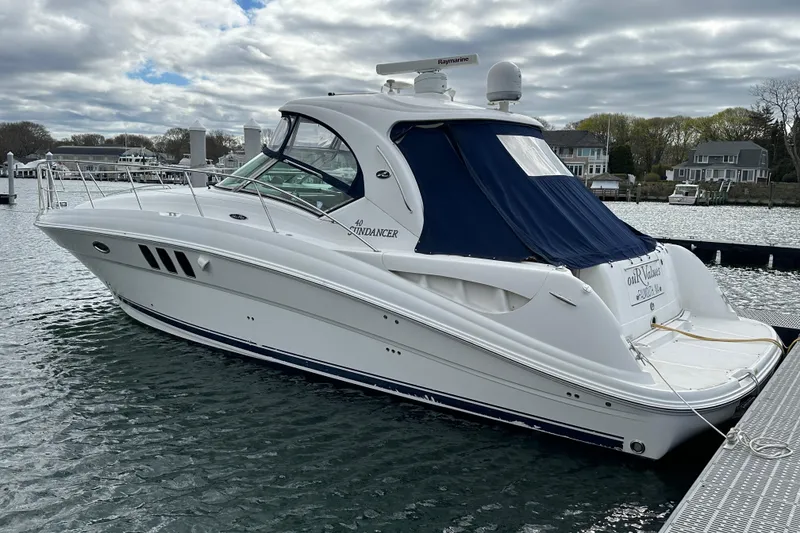 Slide: The Image of 2007 Sea Ray 40 Sundancer yacht docked in a marina under cloudy skies. - 2