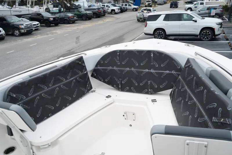 Slide: The Image of 2026 Robalo R232 Explorer boat interior with cushioned seating in a parking lot setting. - 12