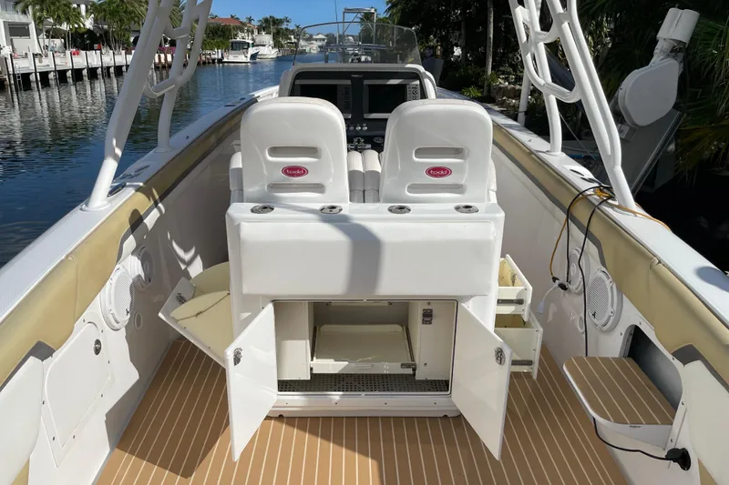 Slide: The Image of 2014 Powerplay Powerboats 35 Open interior with seating and storage, docked by a canal. - 13