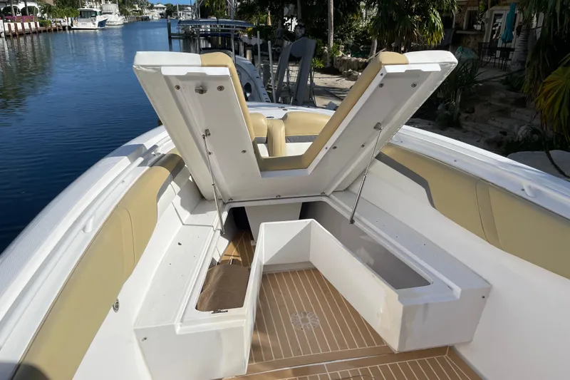 Slide: The Image of 2014 Powerplay Powerboats 35 Open with open storage compartment, docked by a scenic waterway. - 24
