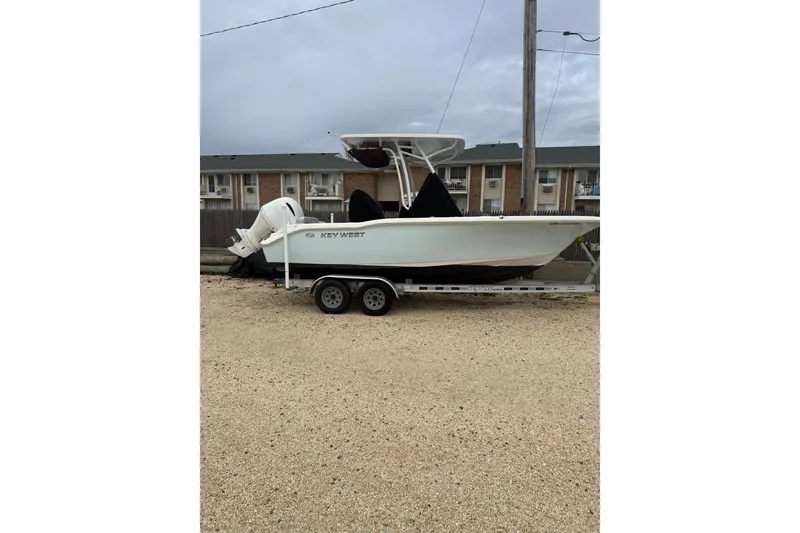 Slide: The Image of 2023 Key West 219 FS boat on trailer, parked outdoors. - 5