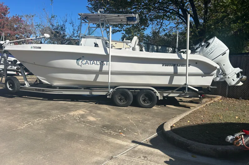 Slide: The Image of 2021 Twin Vee 260 VIVA boat on trailer, parked outdoors, featuring Suzuki outboard motor. - 1