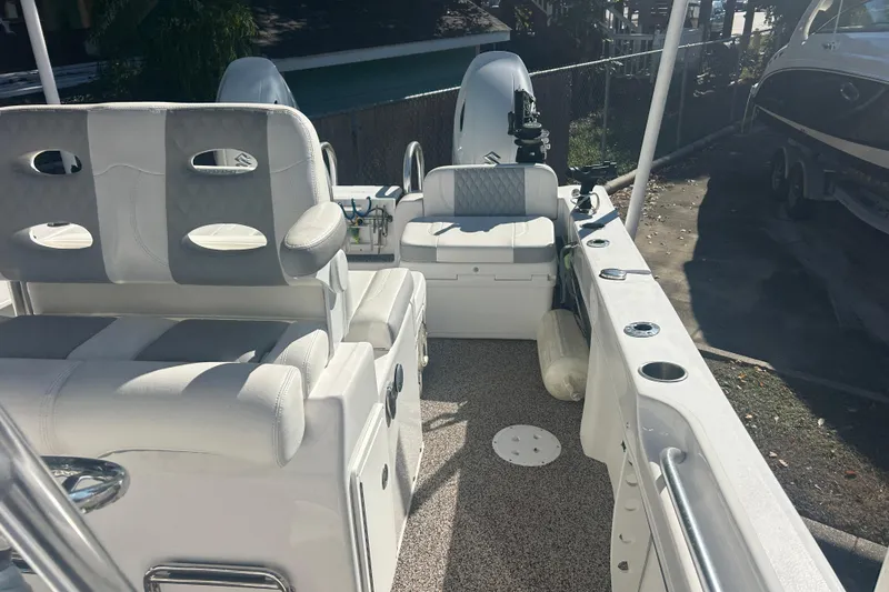 Slide: The Image of 2021 Twin Vee 260 VIVA boat interior with cushioned seating and fishing rod holders. - 15