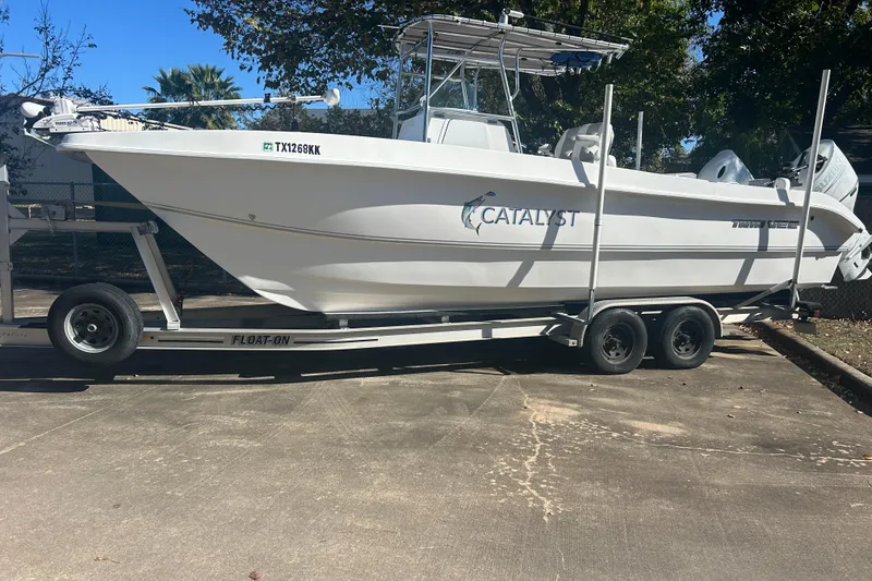Slide: The Image of 2021 Twin Vee 260 VIVA boat on trailer, labeled "Catalyst," parked outdoors. - 2