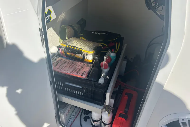 Slide: The Image of Storage compartment of 2021 Twin Vee 260 VIVA boat with various equipment and supplies. - 25