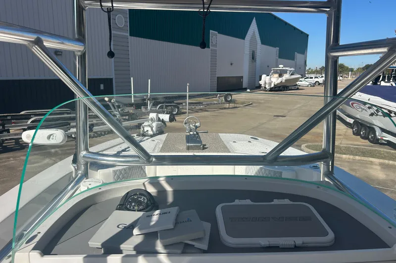 Slide: The Image of 2021 Twin Vee 260 VIVA boat dashboard with compass and manuals, docked at marina. - 33