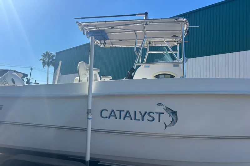 Slide: The Image of 2021 Twin Vee 260 VIVA boat named "Catalyst" with fishing graphic, docked near a green building. - 6