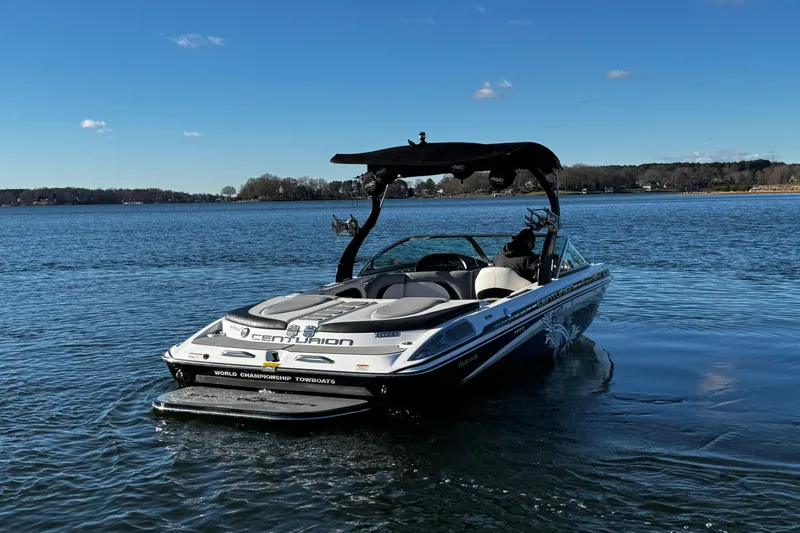 Slide: The Image of 2012 Centurion Enzo SV211 boat on a calm lake under a clear blue sky. - 10
