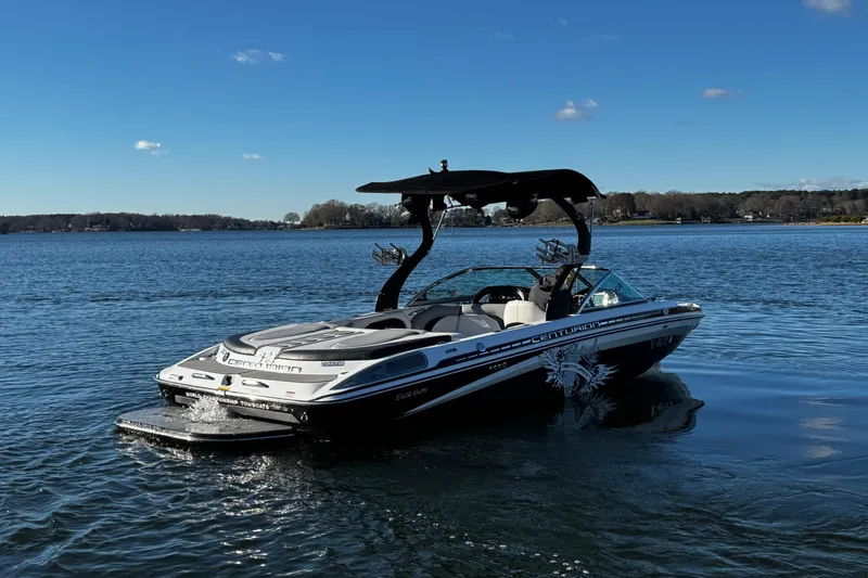Slide: The Image of 2012 Centurion Enzo SV211 boat on a calm lake under a clear blue sky. - 11
