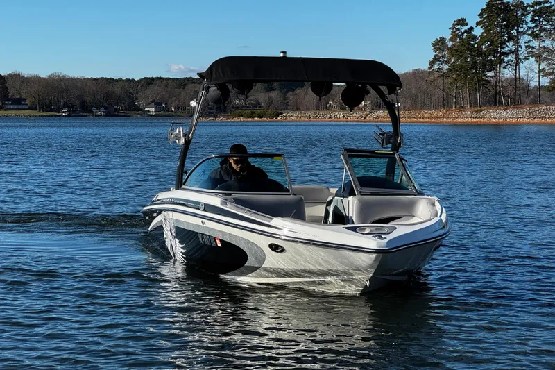 Slide: The Image of 2012 Centurion Enzo SV211 boat cruising on a calm lake under clear skies. - 2