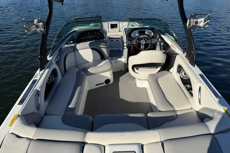 Slide: The Image of 2012 Centurion Enzo SV211 boat interior with plush seating and modern dashboard on water. - 21