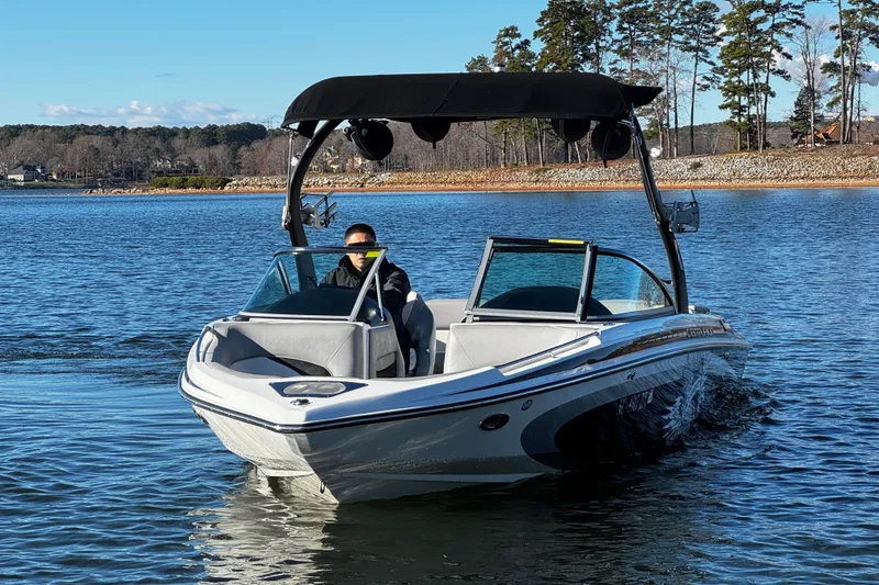 Slide: The Image of 2012 Centurion Enzo SV211 boat cruising on a scenic lake with trees in the background. - 3