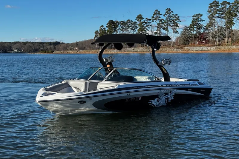 Slide: The Image of 2012 Centurion Enzo SV211 boat on a serene lake with trees in the background. - 4