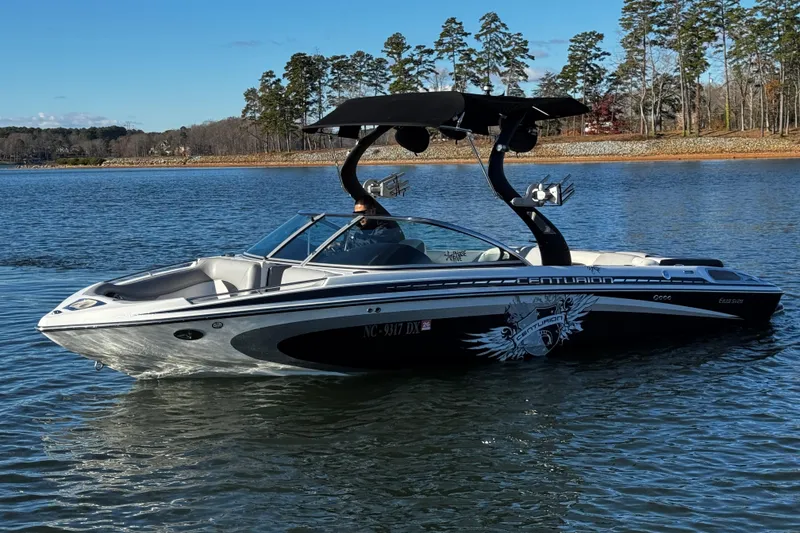 Slide: The Image of 2012 Centurion Enzo SV211 boat on a serene lake with trees in the background. - 5