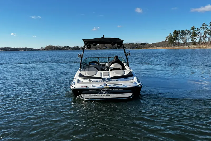 Slide: The Image of 2012 Centurion Enzo SV211 boat on a calm lake under a clear blue sky. - 9