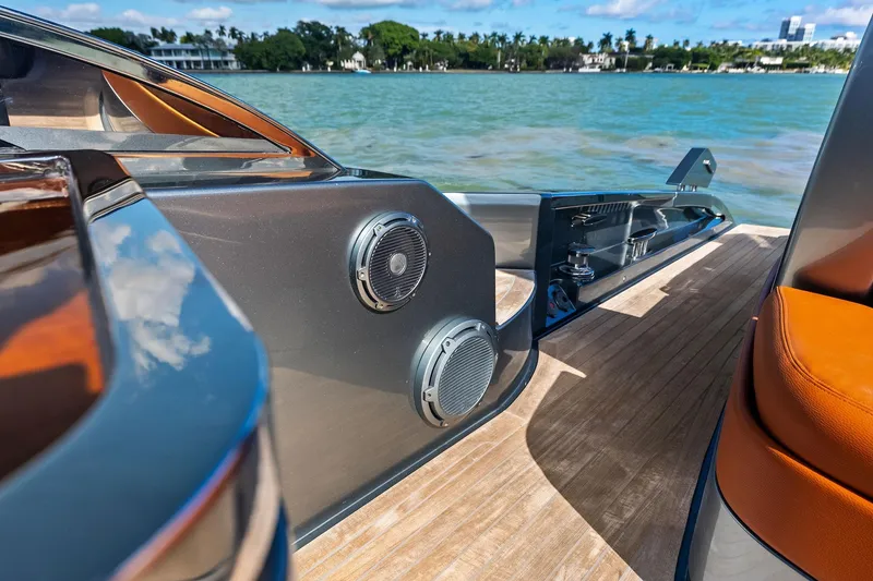 Slide: The Image of Luxury 2021 Riva 56 Rivale yacht deck with speakers, overlooking serene water and lush shoreline. - 18
