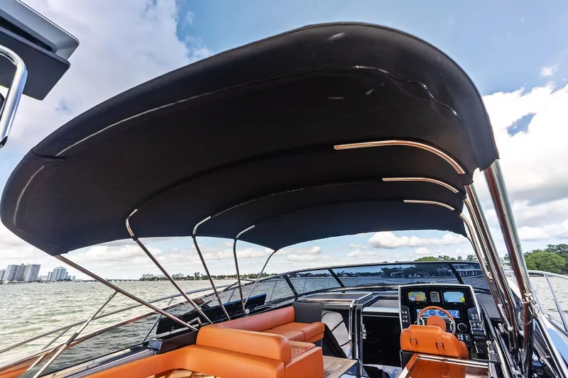 Slide: The Image of 2021 Riva 56 Rivale yacht interior with canopy, featuring luxurious seating and modern dashboard. - 22