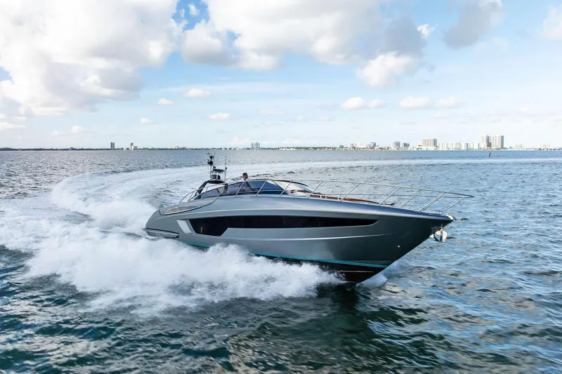 Slide: The Image of 2021 Riva 56 Rivale yacht cruising on open water under a partly cloudy sky. - 6