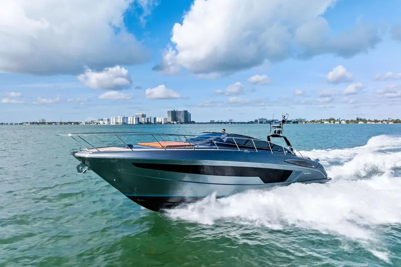 Slide: The Image of 2021 Riva 56 Rivale yacht cruising on open water under a blue sky. - 2