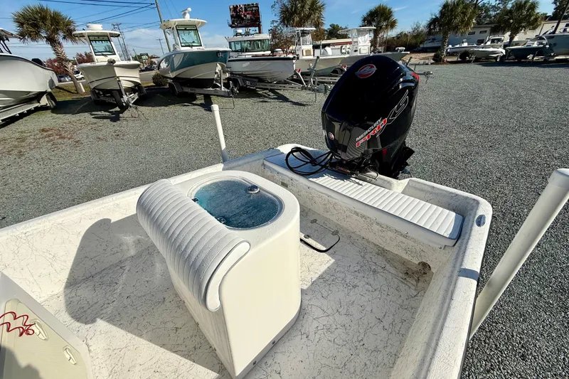 Slide: The Image of 2023 Rabco R21 boat with outboard motor, parked among other boats on gravel. - 11