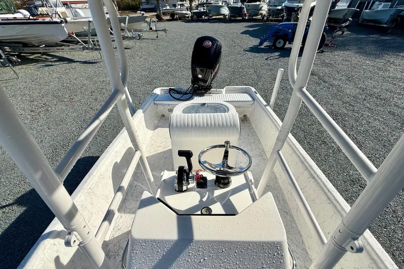 Slide: The Image of 2023 Rabco R21 boat interior with steering wheel and controls, parked among other boats. - 22