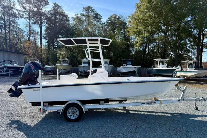 Slide: The Image of 2023 Rabco R21 boat on trailer, parked outdoors with other boats in background. - 7