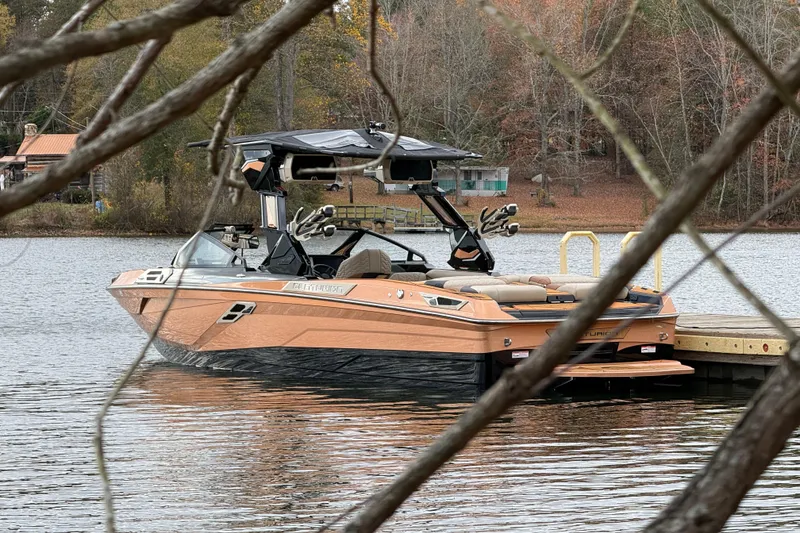Slide: The Image of 2025 Centurion Ri265 boat docked on a serene lake with autumn foliage. - 11