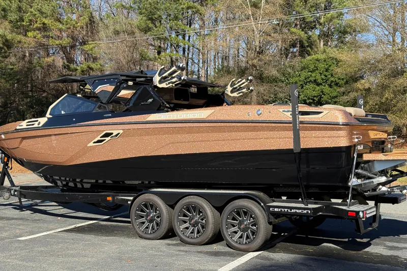 Slide: The Image of 2025 Centurion Ri265 boat on trailer, metallic finish, parked outdoors. - 12
