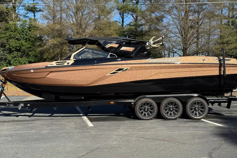 Slide: The Image of 2025 Centurion Ri265 boat on trailer, parked outdoors, featuring sleek design and modern aesthetics. - 13