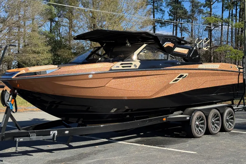 Slide: The Image of 2025 Centurion Ri265 boat on trailer, metallic finish, parked outdoors. - 14