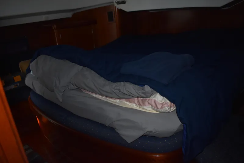 Slide: The Image of Cabin of Beneteau Oceanis 42CC yacht, 2002 model, featuring a cozy bed. - 22