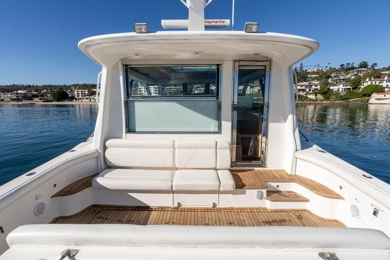 Slide: The Image of 2006 Tiara Yachts 5200 Sovran Salon, rear deck view with seating, docked by waterfront homes. - 11