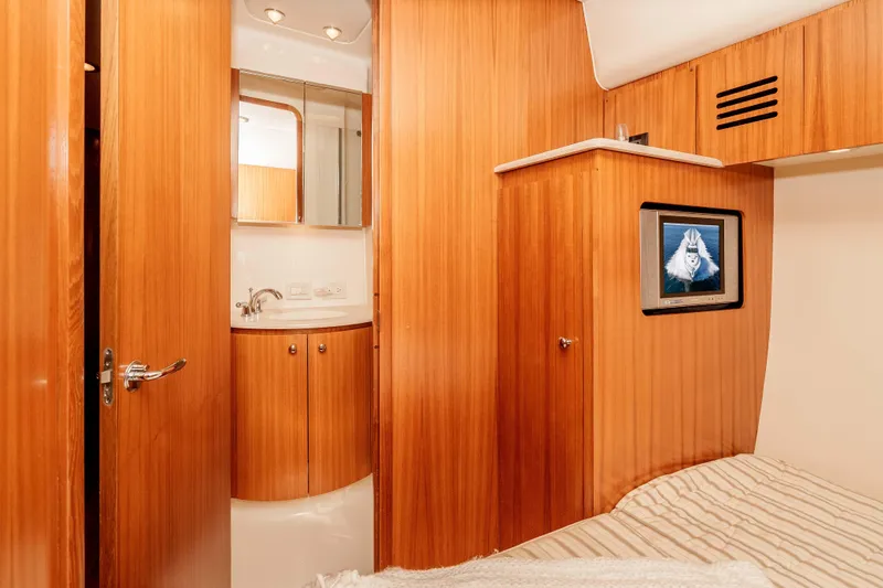 Slide: The Image of Luxurious 2006 Tiara Yachts 5200 Sovran Salon interior with wood paneling and compact bathroom. - 30