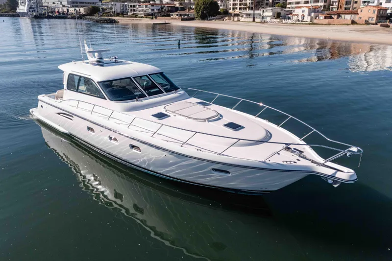 Slide: The Image of 2006 Tiara Yachts 5200 Sovran Salon cruising on calm waters near a coastal town. - 5