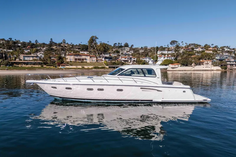 Slide: The Image of 2006 Tiara Yachts 5200 Sovran Salon cruising on calm waters near a coastal town. - 6