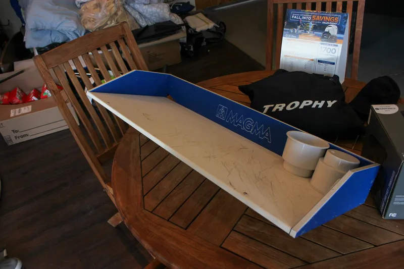 Slide: The Image of Wooden table with Magma grill tray, Trophy shirt, and promotional materials. - 30