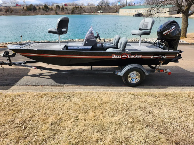 Slide: The Image of 2021 Tracker Bass Tracker Classic XL boat by a lake, on a trailer. - 9