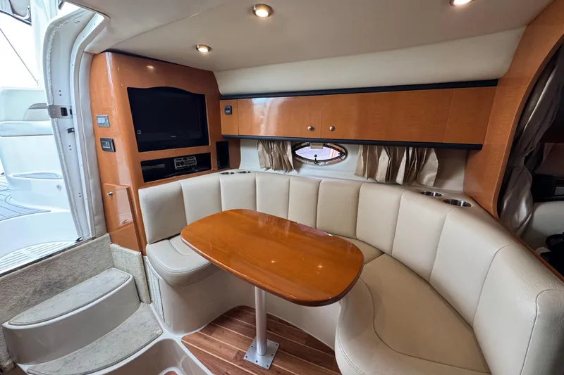 Slide: The Image of 2009 Chaparral Signature 290 interior with cozy seating, wooden table, and entertainment system. - 13