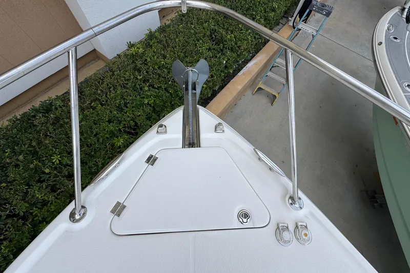 Slide: The Image of Bow of 2009 Chaparral Signature 290 with anchor and railing, docked near greenery. - 27
