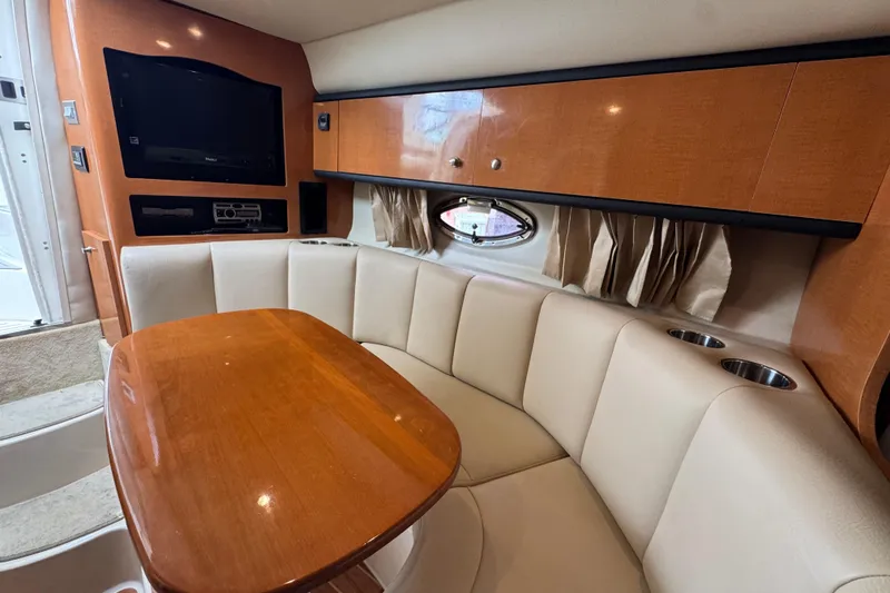 Slide: The Image of 2009 Chaparral Signature 290 interior with cozy seating, wooden table, and entertainment system. - 9