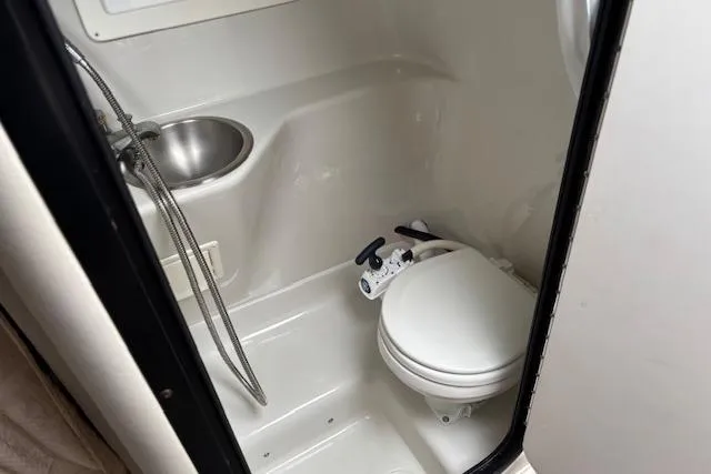 Slide: The Image of Compact bathroom in 2001 Crownline 242 CR boat with toilet and sink. - 12