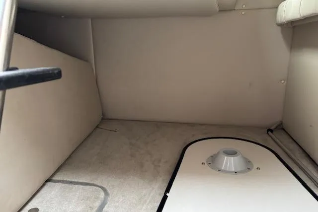 Slide: The Image of Interior cabin of a 2001 Crownline 242 CR boat, featuring beige upholstery. - 13