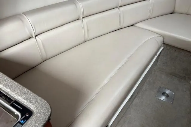 Slide: The Image of 2001 Crownline 242 CR boat interior with beige leather seating and carpeted floor. - 16